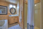 Upstairs master bathroom with a jetted tub and shower stall
